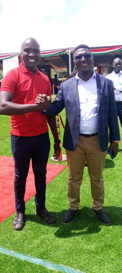 Atonga shaking hands with a community member at an event